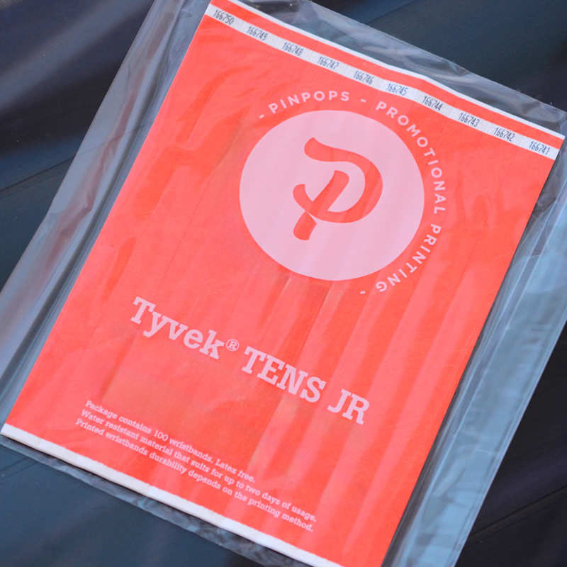 Neon Orange Tyvek Tens wristband with a permanent closure. Prenumbered in sequential order.