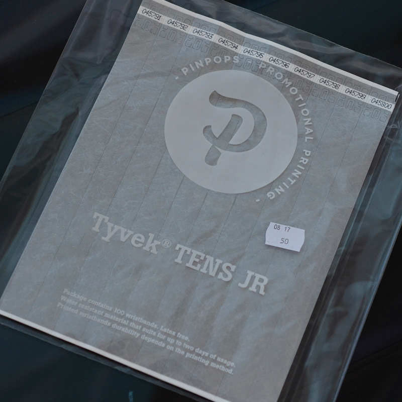 Silver metallic Tyvek Tens wristband with a permanent closure. Prenumbered in sequential order.